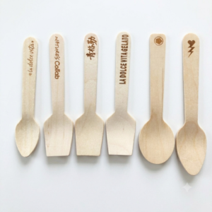 A display of custom wooden ice cream spoons in 70mm to 110mm sizes featuring laser engraved logos for gelato shops.